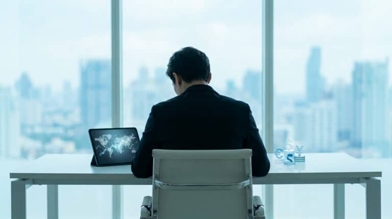 Homme d'affaires de dos face à une vue panoramique urbaine, travaillant sur une tablette avec une carte du monde.